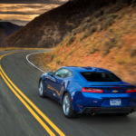 Blauer Chevrolet Camaro der sechsten Generation von hinten auf einer Bergstraße