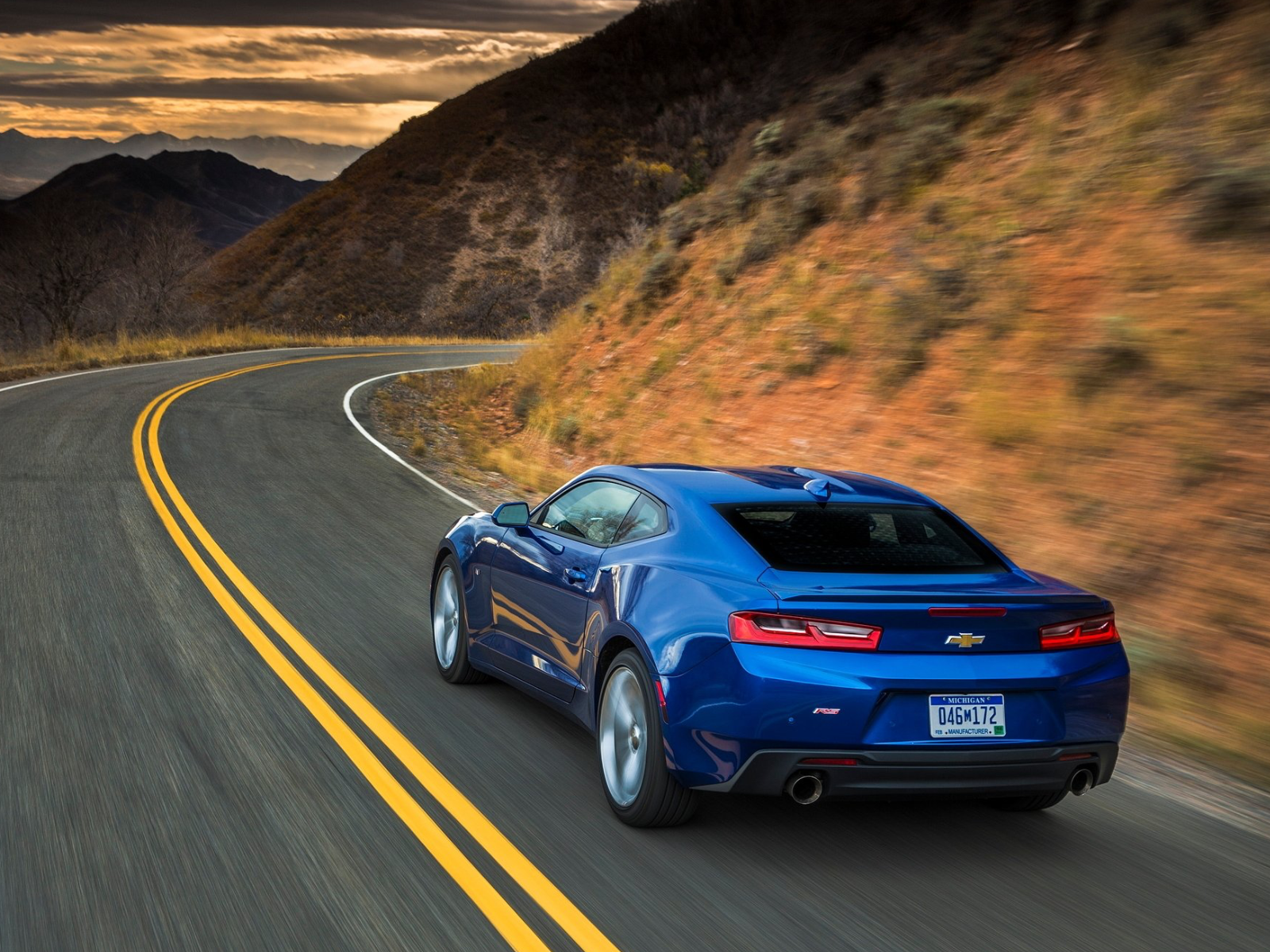 Blauer Chevrolet Camaro der sechsten Generation von hinten auf einer Bergstraße