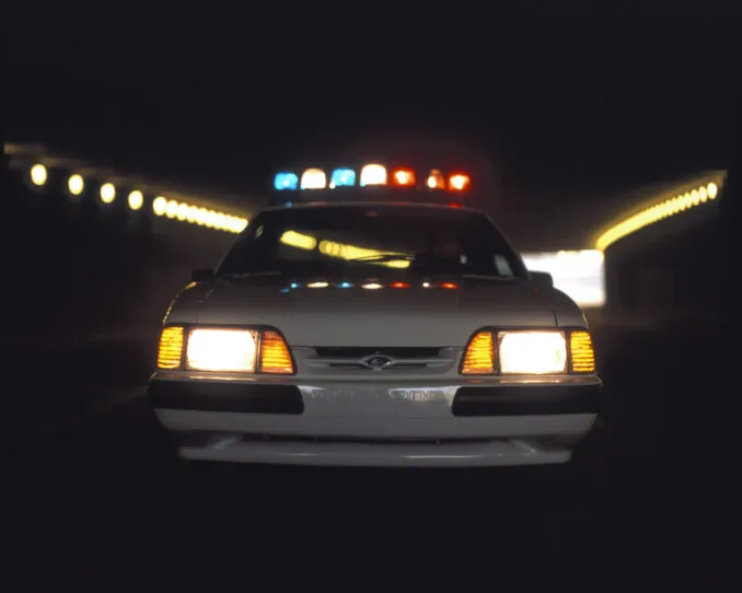 Weißer Ford Mustang SSP des Modelljahres 1993 mit eingeschaltetem Polizeilicht
